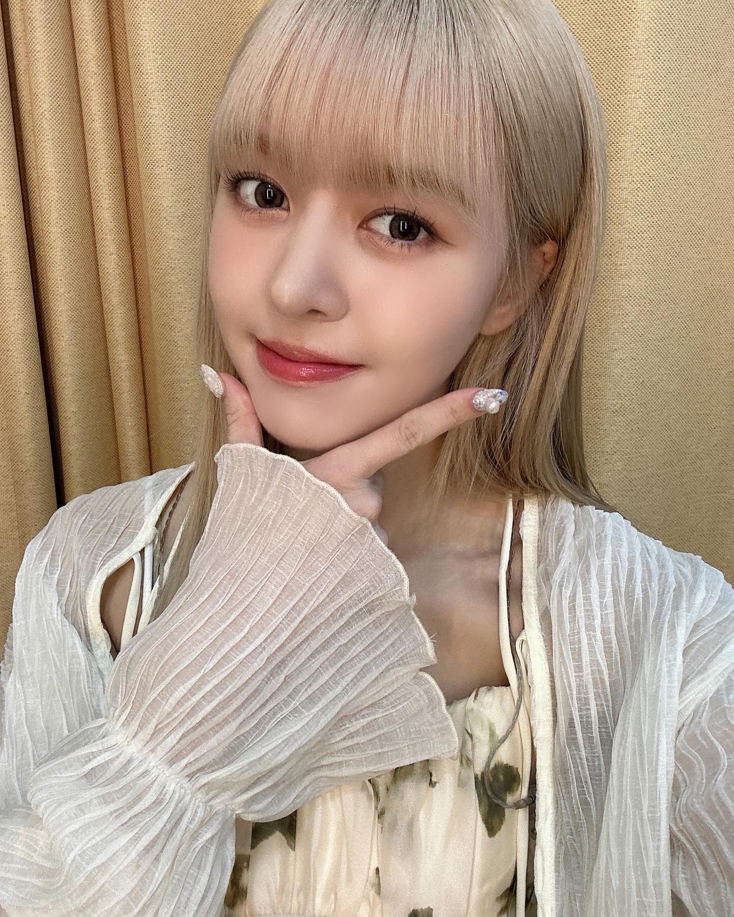 Lily fazendo o aegyo de mão no queixo