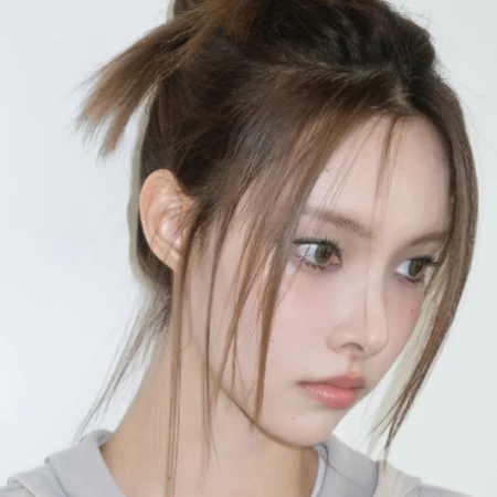 Yunah, do grupo ILLIT, demonstrando um dos penteados de idols da lista