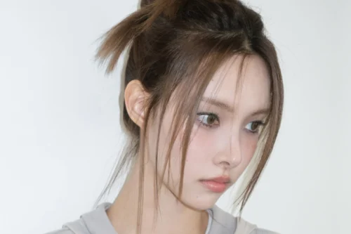 Yunah, do grupo ILLIT, demonstrando um dos penteados de idols da lista