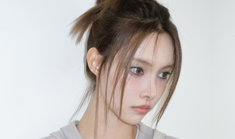 Yunah, do grupo ILLIT, demonstrando um dos penteados de idols da lista